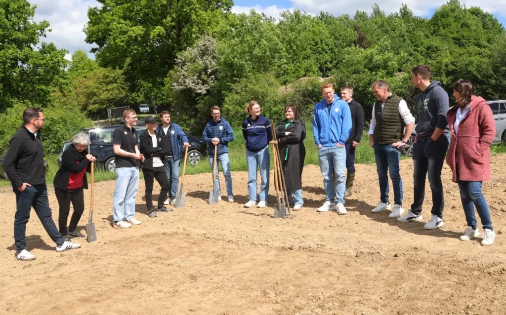 Blühwiese anlegen als Teamevent Team mit Spaten beim gemeinsamen Aussaat-Event von Feldwerk